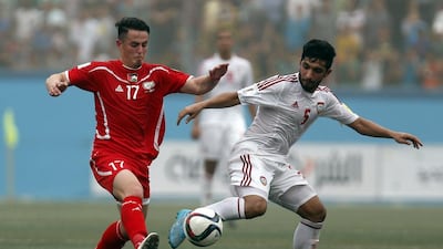 UAE’s Amer Abdulrahman, right, vies for the ball with Palestine’s Pablo Tamburrini during their 2018 World Cup qualifying match at the Faisal Al Husseini Stadium in the West Bank town of Al Ram on Tuesday. Ahmad Gharabli / AFP