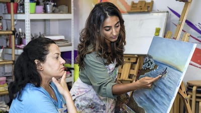 Art teacher Asareh Ebrahimpour with student Haifa Salama at the school. Victor Besa / The National
