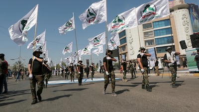 The Iran-backed Popular Mobilisation Forces march with flags in Baghdad, Iraq. The US Defence secretary has called on 'maxmimum pressure' on Tehran to reign in its allies and militia forces. Khalid Mohammed / AP
