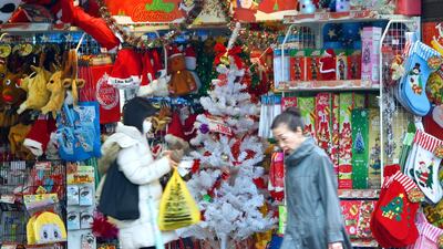 People walk past a discount store selling Christmas goods in Tokyo. Toru Yamanaka / AFP