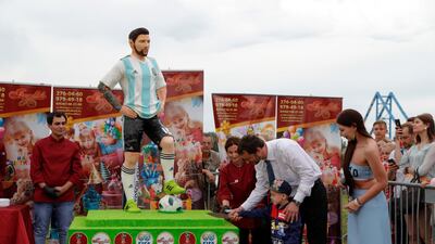 The mayor of Bronnitsy helps a boy cut a cake to mark Lionel Messi's birthday. AP