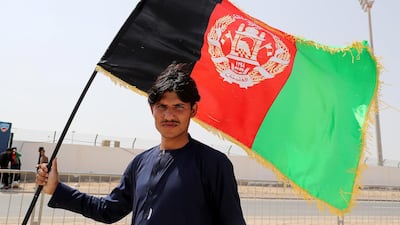 Sahid Jahaan, a supporter of the Afghanistan cricket team, carrying the Afghan flag outside the Sheikh Zayed Cricket Stadium in Abu Dhabi. Pawan Singh / The National