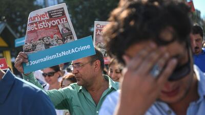 Journalists hold banners and copies of Cumhuriyet daily reading "We want Justice" as they march to the courthouse from Cumhuriyet daily's headquarters on July 24, 2017 in Istanbul. Ozan Kose / AFP