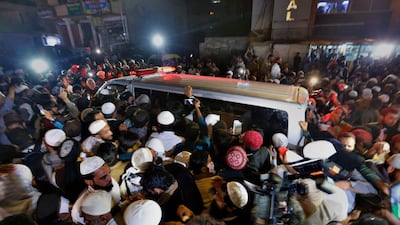 People gathered around the ambulance carrying the body of Maulana Samiul Haq as it left leaving a hospital in Rawalpindi. AP