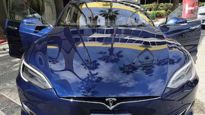 A Tesla Model S on display in downtown Los Angeles. Tesla Motors has reported a rare profit for the third quarter, while Ford's earnings have plunged. Richard Vogel / AP
