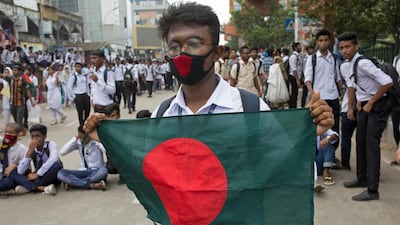 A Bangladeshi student holds a national flag and animates people to join the 'Safe roads movement' during a rally demanding safe roads on the seventh consecutive day of protests, in Dhaka city, Bangladesh. EPA / MONIRUL ALAM
