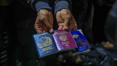 A man displays British, Polish and Australian passports next to the bodies of World Central Kitchen workers at Al Aqsa Hospital in Deir Al Balah, Gaza. AFP