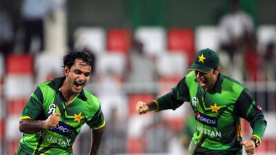 Pakistani spinner Mohammad Hafeez (L) and captain Misbah ul-Haq celebrate after the dismissal of Australian captain Michael Clarke during the first One Day International cricket match between Pakistan and Australia at the Sharjah cricket stadium on August 29, 2012. Pakistan were restricted to 198 in the 45th over in the first of three limited overs. AFP PHOTO / AAMIR QURESHI