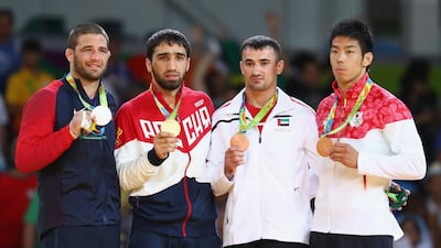 Sergiu Toma, second right, on the podium after winning the bronze medal in the Men's -81kg category. Ryan Pierse / Getty Images