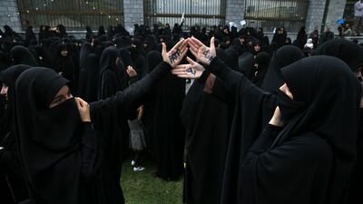 Iranian protesters hold up their palms with writing that reads "No to FATF" during a protest in October against the passage of a bill to counter financing of terrorism. AP