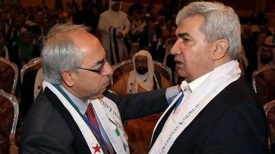 Syrian regime opponent Riad Seif, right, shakes hands with Syrian National Council (SNC) chief Abdel Basset Seda during the meeting of the General Assembly of the Syrian National Council in Doha yesterday.