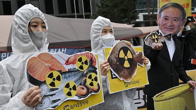 South Korean environmental activists wearing protective clothing and a mask of Japan's Prime Minister Yoshihide Suga hold pictures of fishes with radioactivity warning signs during a protest against Japan's decision on releasing Fukushima wastewater, near the Japanese embassy in Seoul. AFP