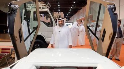 Dr. Hajeri, Chairman of the Gulf Automobile Industry Corporation, standing in front of the first car he ever made.
