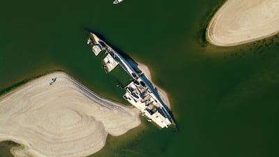This aerial photograph shows the wreckage of a World War II German warship, one of dozens sunk by retreating Nazi forces in September 1944, emerging from the low waters of the Danube River near Prahovo, Serbia, as drought and prolonged hot and dry weather continues to lower water levels across the region. Heat and drought are driving rivers across Europe to record lows. Low levels along the Danube river have already seen Hungary and Romania forced to consider shuttering their nuclear plants, which rely on the water for cooling, in late July, though both managed to avoid doing so for now. AFP