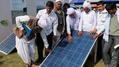Villagers inspect solar panels at the Gujarat Solar Park in Charanka village, in Gujarat state. Research suggests that the state, along with Rajasthan and Karnataka, is flooded with enough sunlight to accommodate large solar power plants.