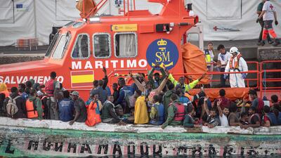Spanish search and rescue team escorts a 'cayuco' boat with 174 migrants onboard disembarking at La Restinga port on the Canary Island of El Hierro on August 31. AFP