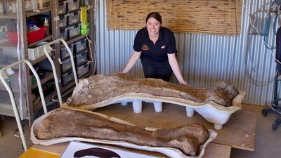 Member of staff Rochelle Lawrence with a giant fossil. Eromanga Natural History Museum / AFP