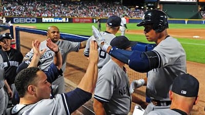 Alex Rodriguez of the New York Yankees is congratulated by teammates