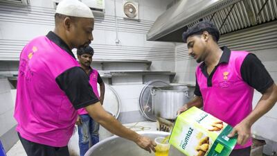 Cooks put oil into a big pot to prepare a nutritious porridge to serve during iftar.