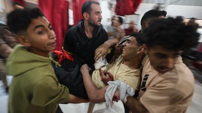 Palestinians carry an injured man to hospital after Israeli strikes. AFP