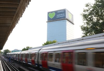 A London Underground train passes the covered remains of Grenfell Tower. Reuters