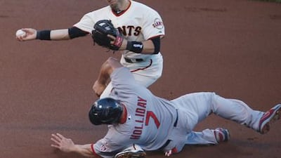 St Louis Cardinals' Matt Holiday slides painfully into San Francisco's Marco Scutaro during their playoff game