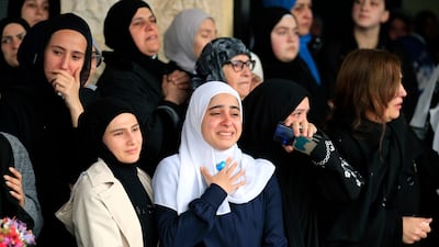 Women mourn during the funeral procession for the paramedics who were killed. AP