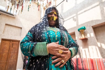 A woman shows off the finished product of a talli sewn at the collar and sleeve of the dress. Ruel Pableo for The National