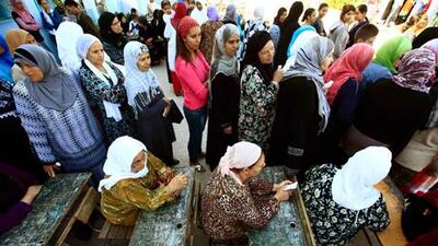 Women line up Sunday for the first free vote in Tunisia's history.