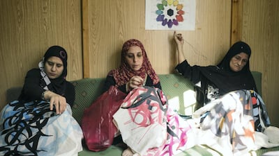 Female Palestinian artisans from Lebanon's Ain Al Heweh refugee camp sew eL Seed's works using tatreez techniques