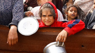 Displaced Palestinian children wait to receive food at a tent camp amid food shortages in Rafah in the southern Gaza Strip. Reuters