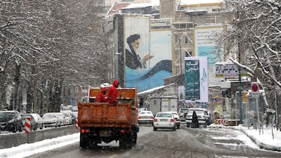 Tehran during snowfall on February 2, 2014. Despite heavy snowfall residents still lined up hoping to receive free food staples as part of a government initiative. Abedin Taherkenareh/EPA