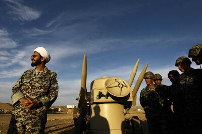 An Iranian clergyman stands next to missiles and army troops, during a manoeuvre, in an undisclosed location in Iran. Mehr News Agency via AP, file