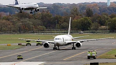 A jet lands near a United Parcel Service jet that is seen isolated on a runway at Philadelphia International Airport.