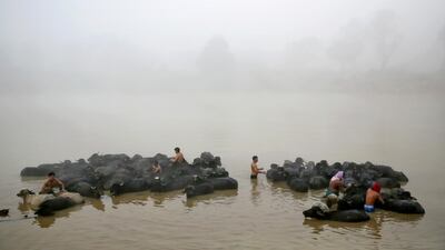 Buffalo herders bathe their cattle amid thick smog on the outskirts of New Delhi, India. Air quality in the capital region, already the worst in the world, is hovering between "severe" to "poor". AP
