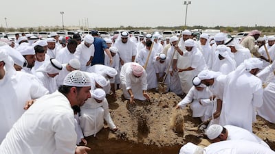 Funeral-goers pay their respects at the burial of Khaled Qai in Al Qusais Cemetery in Dubai. Pawan Singh / The National