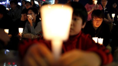 People take part in a candlelight vigil in Ansan, to commemorate the victims of the sunken passenger ship Sewol and to wish for the safe return of missing passengers. Issei Kato / Reuters / April 25, 2014