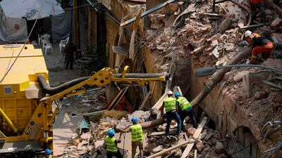 Rescue workers prepare to use a tube to vacuum debris from a badly damaged building in Lebanon's capital Beirut, in search of possible survivors from a mega-blast at the adjacent port one month ago, after scanners detected a pulse. Lebanese rescuers scoured rubble for a possible survivor in Beirut after the detection of a pulse drew crowds hopeful of a miracle one month on from a devastating explosion. AFP