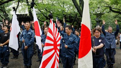 Visitors holding Japanese national flags and a rising sun flag shout 'Banzai' after offering one minute silent prayers for the war dead at Yasukuni Shrine in Tokyo as Japan marked the 72nd anniversary of the end of the Second World War on August. 15, 2017. the shrine also honours 14 convicted war criminals. Kimimasa Mayam / EPA