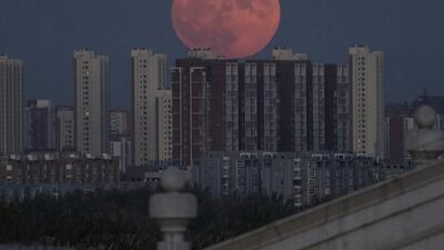 The moon rises from behind apartment buildings in Beijing, China on Monday, November 14, 2016. Ng Han Guan / AP Photo