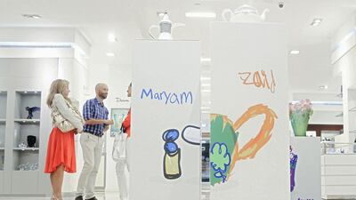 Visitors admire the works of art at the ‘We are all Stars’ exhibition at the Mall of the Emirates. The exhibition displays work by autistic children and has been organised by Dubai Autism Centre and Tanagra. Lee Hoagland / The National