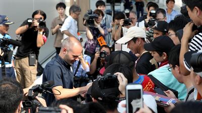 Iniesta signs his autograph for Japanese fans upon his arrival at Kansai International Airport. Jiji Press / EPA