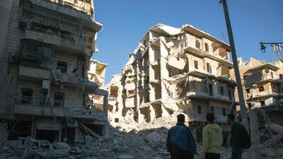 Syrian men look at a heavily damaged building following heavy air strikes on rebel-held eastern areas of Aleppo on September 24, 2016. Karam Al Masri / AFP