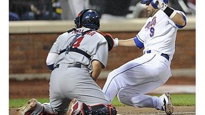 New York Mets' Omir Santos scores on a double by Luis Castillo as the St Louis Cardinals catcher Yadier Molina covers the plate in the fourth inning at Citi Field in New York.