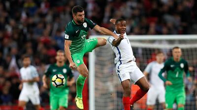 England's Raheem Sterling jumps for the ball with Slovenia's Bojan Jokic. Kirsty Wigglesworth / AP Photo