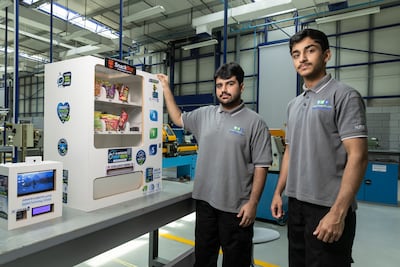 Pupils Ghaith Ebrahim Almansoori and Rashid Abdalrhman with the smart vending machine. Antonie Robertson/The National
