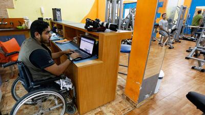 Freelance photographer Moamen Qreiqea uses a laptop computer at a gym.