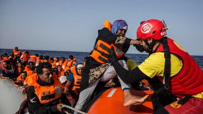 A migrant aboard a rubber dinghy off the Libyan coast is helped by rescuers aboard the Open Arms aid boat, of Proactiva Open Arms Spanish NGO, Saturday, June 30, 2018. 60 migrants were rescued as Italy's right-wing Interior Minister Matteo Salvini tweeted: "They can forget about arriving in an Italian port." (AP Photo/Olmo Calvo)
