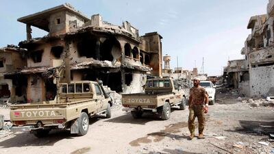 A fighter of Libyan forces allied with the UN-backed government walks past a ruined house in Cambo area which they captured from ISIL militants on October 16, 2016, in Sirte, Libya. Ismail Zitouny/Reuters