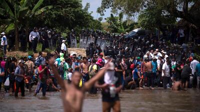 A wall of Mexican Federal Police await a new group of Central American migrants wading across the Suchiate River, that connects Guatemala and Mexico. AP/Santiago Billy